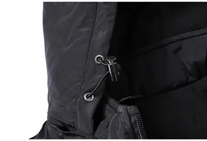 Detailed close-up of winter jacket hood, black fabric with metal drawstrings and zipper.