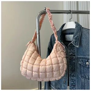 Pink quilted hobo shoulder bag detail, stylish ruffled strap design and soft fabric texture.