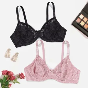 Detailed shot of plus size lace full cup bras in black and pink with elegant props.