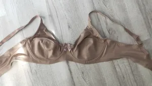 Detail view of the nude full-coverage smoothing bra, highlighting delicate bow and soft fabric.