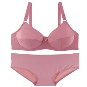 Close-up detail of the pink bra and panty set, showing soft fabric, straps, and front bow.