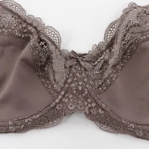 Dettaglio in primo piano di reggiseno coppe grandi con pizzo raffinato e fiocco.