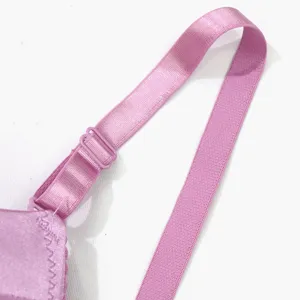 Close-up detail of smooth purple bra adjustable strap and plastic ring buckle accessory.
