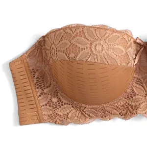 Primo piano del reggiseno mezzo top color carne senza spalline con delicato pizzo floreale e dettagli.