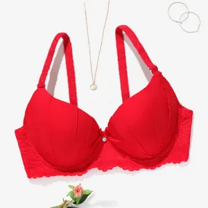 Closeup view of red lace bra featuring thin straps, scalloped edges and center bow detail.