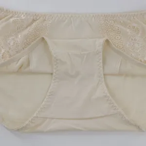 Close-up detail of women mid-waist briefs, featuring soft beige fabric and delicate lace sides.