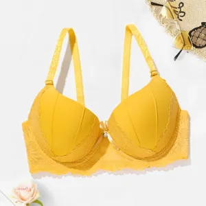 Close-up detail view of the vibrant yellow lace bra cup and delicate bow decoration.
