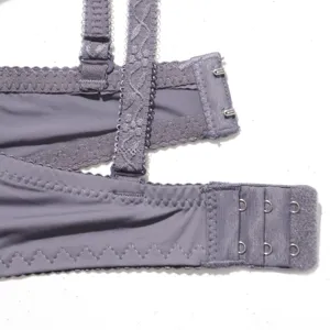 Close-up detailweergave van de grijs-paarse bh-rugsluiting en decoratieve schouderband.