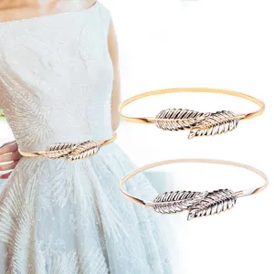 Gold leaf metal waist chain detail, elastic dress belt close up for women fashion.