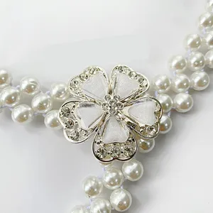 Pearl waist chain detail showing silver rhinestone flower buckle and faux pearls.
