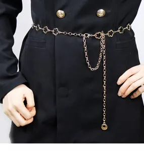 Gold flower chain belt, delicate clover links with dangling tassel, chic waist accessory.