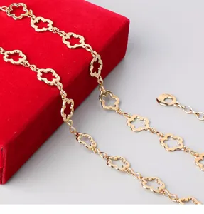Golden metal flower waist chain dress accessory, chic hollow clover link design for women.