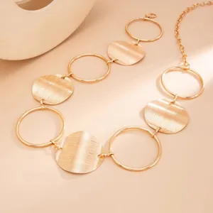Gold metal chain belt detail shot, geometric disc and ring links, stylish waist accessory.