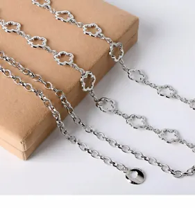 Silver metal flower waist chain with hollow clover charms, fashion dress accessory belt.