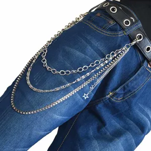 Close-up detail shot of multi-layer metal trouser chain with star pendant on blue jeans.