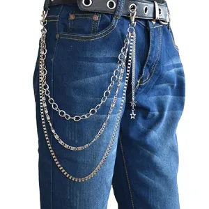 Close-up detail of multi-layer metal hip-hop trouser chain with star pendant on denim jeans.
