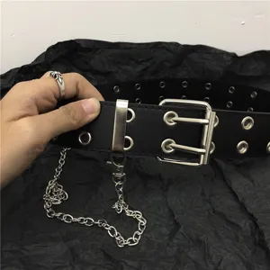 Detail view of black punk double grommet leather belt with metal chain and buckle.