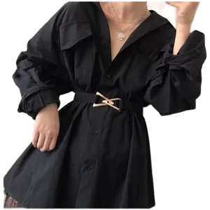 Women's black oversized dress paired with a stylish metallic triangle buckle waist belt.
