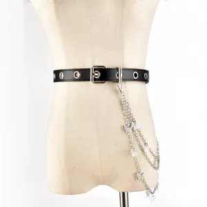 Detailed view of punk black leather belt with silver metal grommets and butterfly chains.
