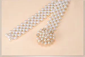 Detailed view of an elegant elastic pearl waist belt with a sparkling rhinestone flower buckle.