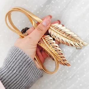 Gold metal leaf buckle elastic waist belt detail shot, elegant decorative waist chain.
