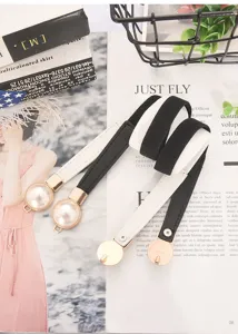 Detailed view of women elastic waist belt with stylish pearl buckle and contrast strap.