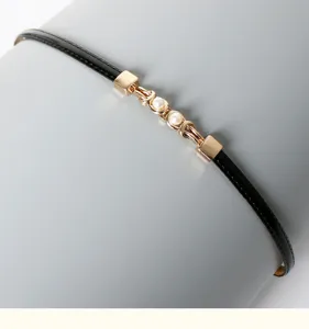 Elegant black thin PU leather dress belt with chic gold metal and pearl detail for women.