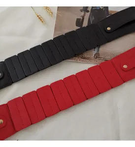 Nahaufnahme des breiten elastischen Taillengürtels mit segmentiertem Design und Druckknöpfen.