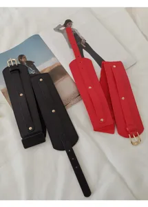 Detailaufnahme von breiten elastischen Taillengürteln in Schwarz und Rot mit Metallschnalle.