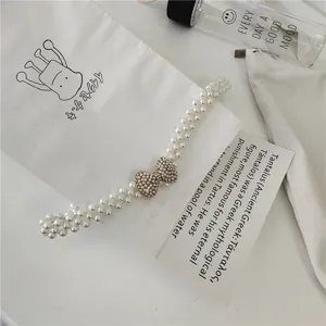 Pearl waist chain detail shot, stylish rhinestone bow design, perfect dress accessory.