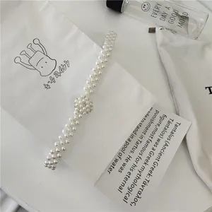 Pearl waist chain detail featuring delicate beaded flower clasp and stylish multi-strand look.