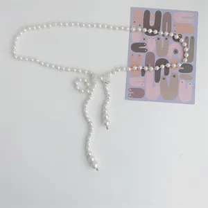 Pearl waist chain for women, elegant bow rhinestone accessory for dresses and sweaters.