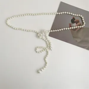Exquisite pearl waist chain with sparkling crystal floral buckle, elegant dress accessory.