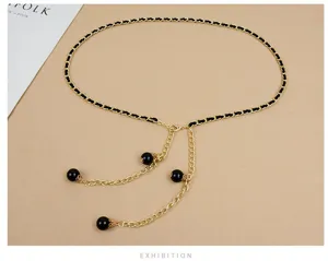 Women's fashion gold chain waist belt with black ribbon and elegant pearl pendant design.