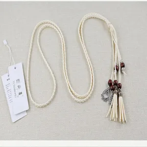 Handmade boho woven waist belt with wooden beads and tassels, delicate dress accessory.