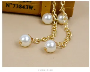 Gold metal chain with white pearl details, close-up view showing exquisite craftsmanship.