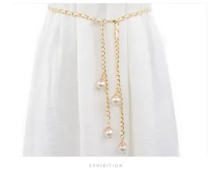 Close-up of a delicate gold chain belt with elegant pearl pendants, perfect for dresses.