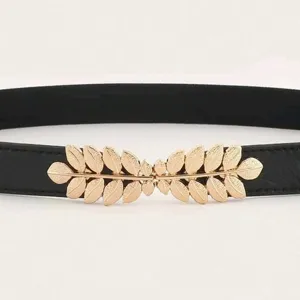 Détail de la ceinture noire minimaliste dotée d'une boucle métallique dorée en forme de feuilles.