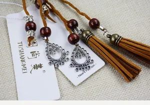 Close-up detail of ethnic handmade waist belt with brown suede cords, wooden beads, and tassels.