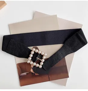 Close-up detail of stylish women's black elastic waist belt with pearl square buckle.