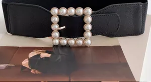 Detail view of women's black elastic waist belt featuring a chic square pearl buckle design.