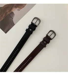 Close-up detail of slim leather belts featuring metal pin buckles and adjustable designs.