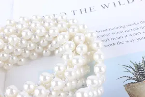 Gros plan détaillé de la chaîne de taille élégante en perles blanches pour robes et pulls.