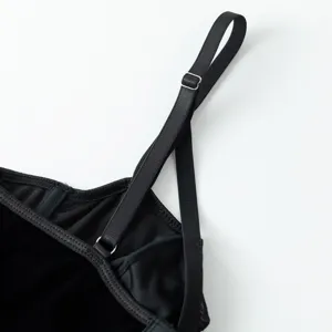 Black velvet camisole strap detail closeup, showing adjustable metal buckle and soft fabric.
