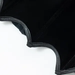 Detailed view of black velvet gothic corset top fabric texture and edge stitching craftsmanship.