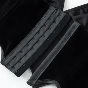 Black gothic velvet corset detail close-up showing metal hook and eye closures.