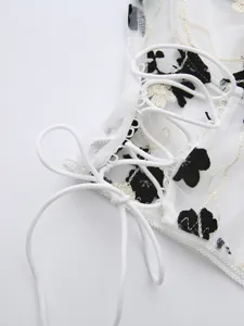 White mesh corset top featuring black floral embroidery and lace-up front details for women.