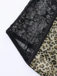 Close-up detail of sexy leopard print and black floral lace patchwork corset top fabric.