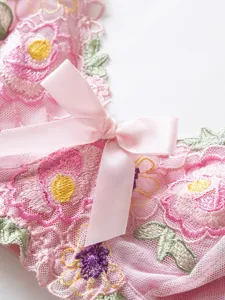 Detailed close-up of pink floral mesh embroidered bralette featuring sweet satin bow accent.