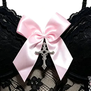 Schwarzes Spitzenoberteil mit rosa Schleife und silbernem Kreuz-Anhänger Vorderseite.